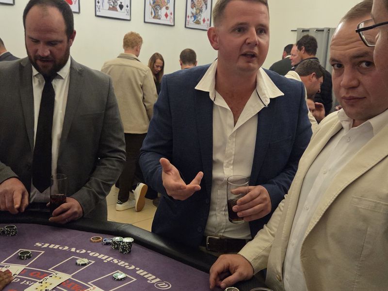 Guests chatting around a blackjack table at a fun casino evening