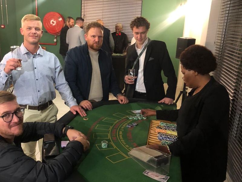 Guests at a green blackjack table while the croupier deals