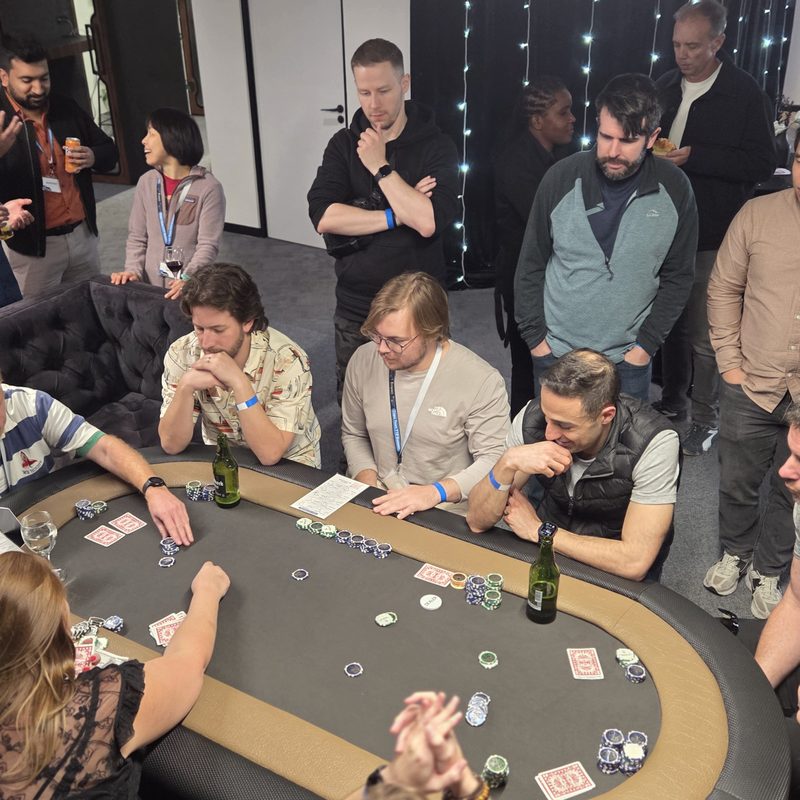 Players and onlookers around a poker table at a corporate fun casino event