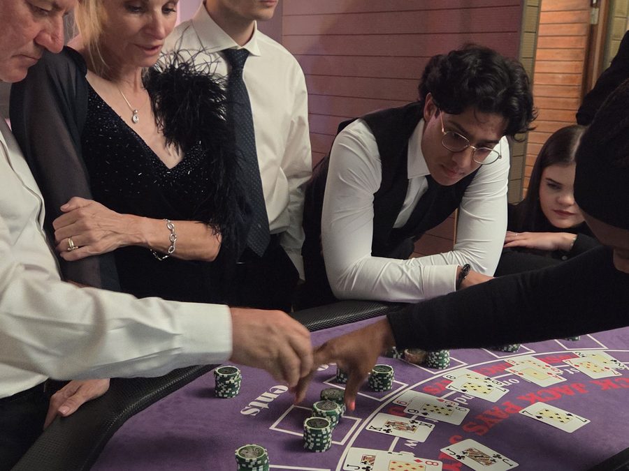 Croupier dealing blackjack to guests in evening wear at a fun casino table