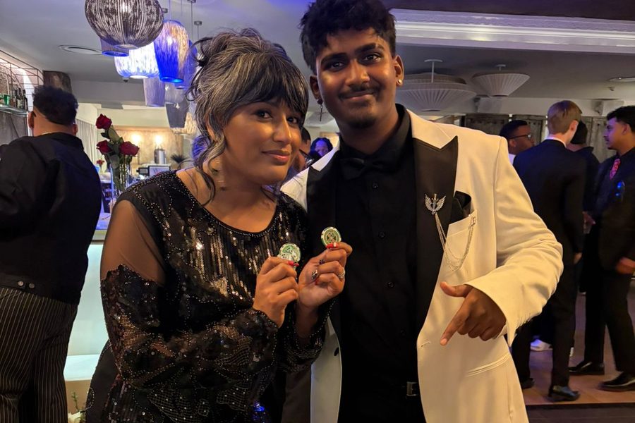 Two guests in formal evening wear holding casino chips at a private fun casino party
